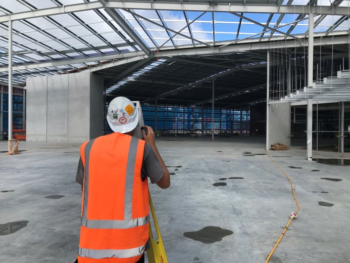 Surveyor surveying warehouse construction