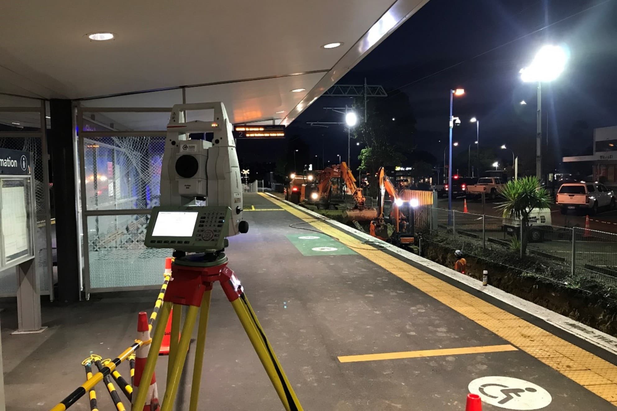 Image of surveying device on a tripod on a rail station platform