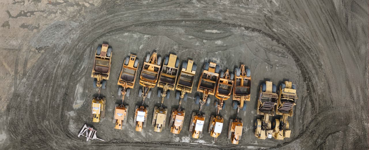 Image from above if many parked earthmoving machines on a development site